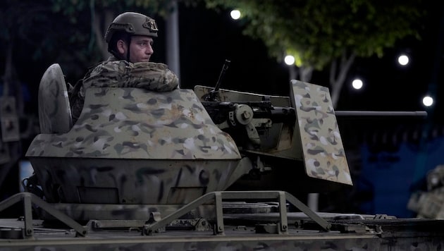 A Lebanese army soldier sits on the roof of an armored personnel carrier in a southern suburb of Beirut on Tuesday morning. (Bild: AP)