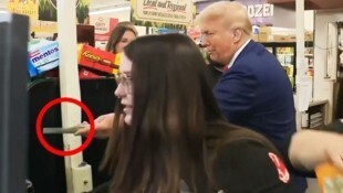 Präsidentschaftsanwärter Donald Trump steckt einer Kundin einen 100 Dollarschein zu.