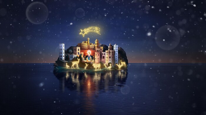 The nativity scene on the lake is brightly lit.