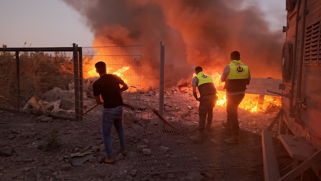 Rescuers rush to help during an Israeli airstrike on the southern Lebanese village of Abbasiyeh. (Bild: APA/AFP/Kawnat HAJU)