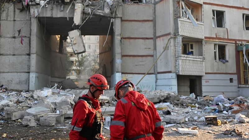 Emergency services in front of a destroyed building (Bild: AFP/Sergey Bobok)