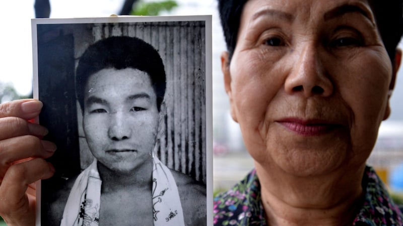 Iwaos Hakamada Schwester Hideko mit einem Foto ihres Bruders als junger Mann. (Bild: APA/AFP)