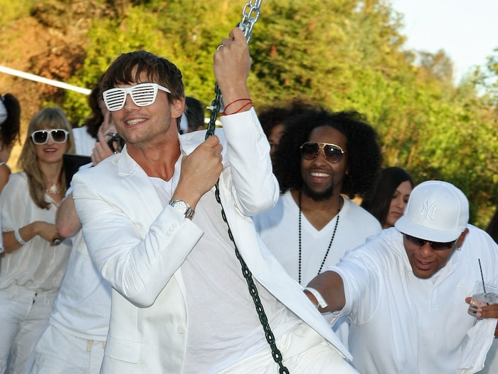 Ashton Kutcher ausgelassen feiernd auf einer der „White Partys“ von . Diddy im Jahr 2009.