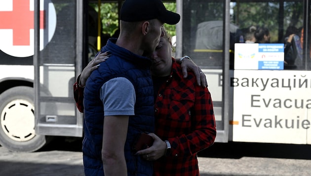 A resident of Pokrovsk says goodbye to his wife in front of an evacuation bus. (Bild: APA/AFP/Genya SAVILOV)