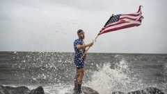 YouTuber Mark Peyton hält kurz vor der Ankunft „Helenes“ eine US-Flagge an der Küste Floridas hoch. (Bild: AFP)