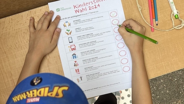 Child fills in the SOS Children's Village ballot paper in the voting booth. (Bild: SOS Kinderdorf)