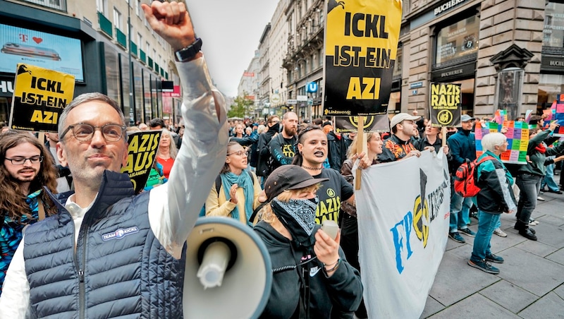 Während sich FPÖ-Chef Herbert Kickl von seinen Anhängern feiern ließ, demonstrierten Gegner der Freiheitlichen abseits der Bühne mit Parolen wie „Nazis raus“.(Bild: Krone KREATIV/AP APA) (Bild: Krone KREATIV/AP APA)