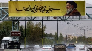 Im Norden der iranischen Hauptstadt Teheran hängt ein Banner mit dem getöteten Hisbollah-Chef Hassan Nasrallah. (Bild: APA/AFP/ATTA KENARE)