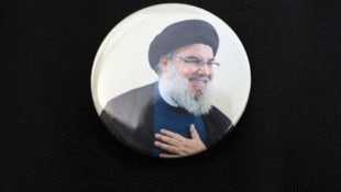 Ein Iraker trägt bei der Beerdigung eines Militärkommandanten der irakischen Hisbollah-Brigaden in Bagdad eine Anstecknadel mit dem libanesischen Hisbollah-Chef Hasan Nasrallah. (Bild: APA/AFP/AHMAD AL-RUBAYE)