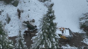 Der Pkw stürzte über einen Abhang und krachte gegen einen geparkten Bagger. (Bild: KaPo Graubünden)