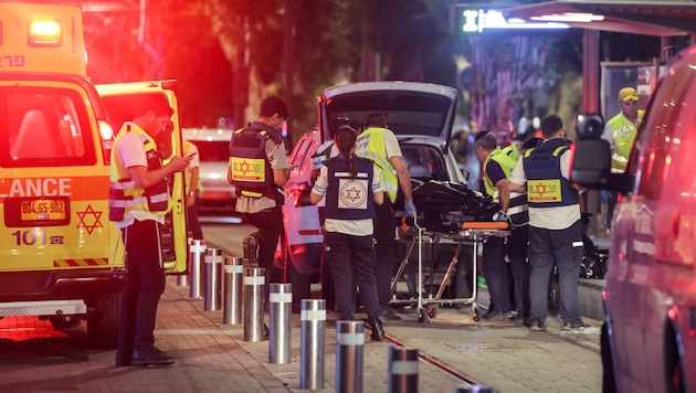 Volunteers carry away a deceased person in Tel Aviv. (Bild: APA/AFP/Jack GUEZ)