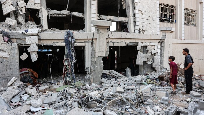 Ein Mann und ein Bub begutachten die Schäden, nachdem Israel eine Schule im Gazastreifen ...