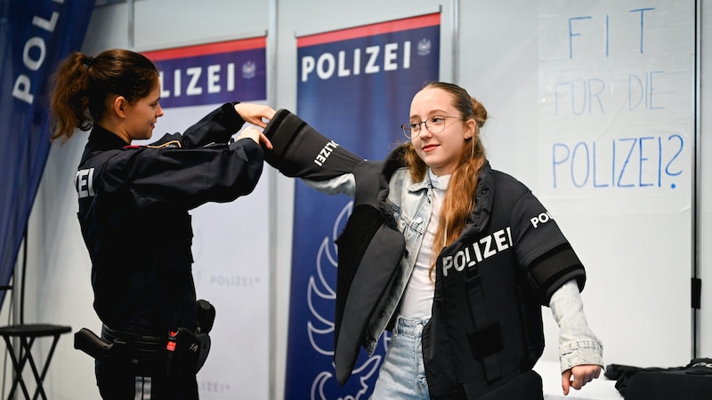 Die Polizei lässt Interessierte eine Schussweste überziehen, mit der man Liegestütze machen kann. (Bild: Wenzel Markus)