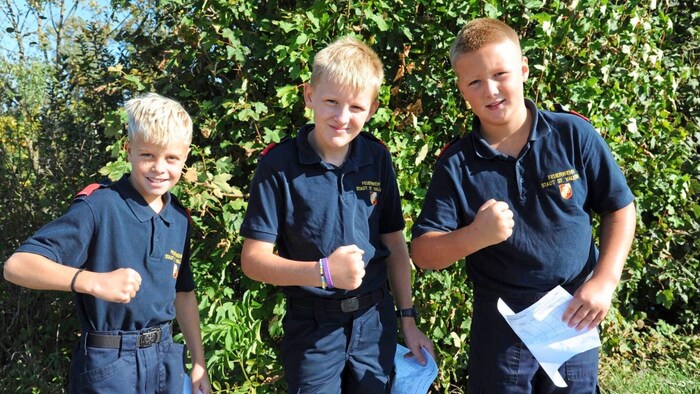 The young firefighters' joy at their achievements is clear to see.