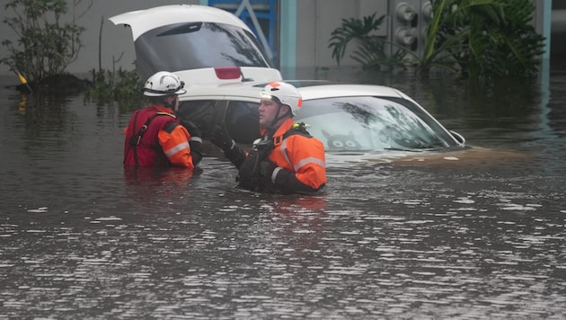 First responders in the water in front of an apartment complex that was inundated by a flooded creek because of "Milton". (Bild: APA/AFP/Bryan R. SMITH)