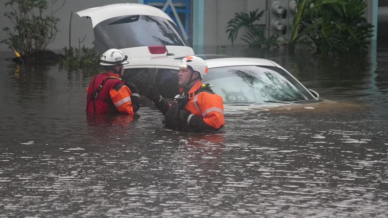 First responders in the water in front of an apartment complex that was inundated by a flooded creek due to "Milton". (Bild: APA/AFP/Bryan R. SMITH)