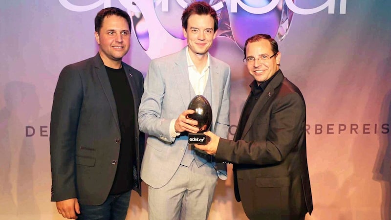 Presenter Philipp Hansa received an "Honorary Adebar" from the President of the Chamber of Commerce, Andreas Wirth, and Ronald Fenk, Chairman of the Trade Group. (Bild: Reinhard Judt)