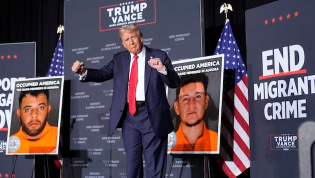 Donald Trump between photos of gang members he wants to deport en masse. (Bild: AP ( via APA) Austria Presse Agentur/Alex Brandon)