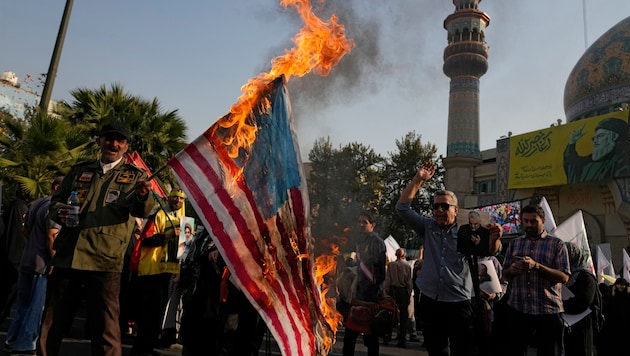 Iranische Demonstranten verbrennen eine US-Flagge bei einer anti-israelischen Versammlung auf dem Felestin Platz in Teheran, Iran. (Bild: AP)