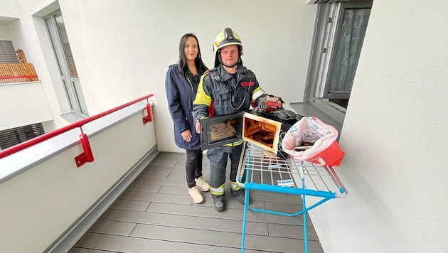 Feuerwehrkommandant Philipp Rath und Lebensretterin Sabrina Imre mit der Mikrowelle, die Feuer fing. (Bild: Bezirksfeuerwehrkommando Oberwart)