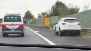 Der Lenker im weißen Mazda fuhr in Schlangenlinien am Pannenstreifen. Der Polizeiwagen befand sich direkt daneben.  (Bild: Screenhot/TikTok)