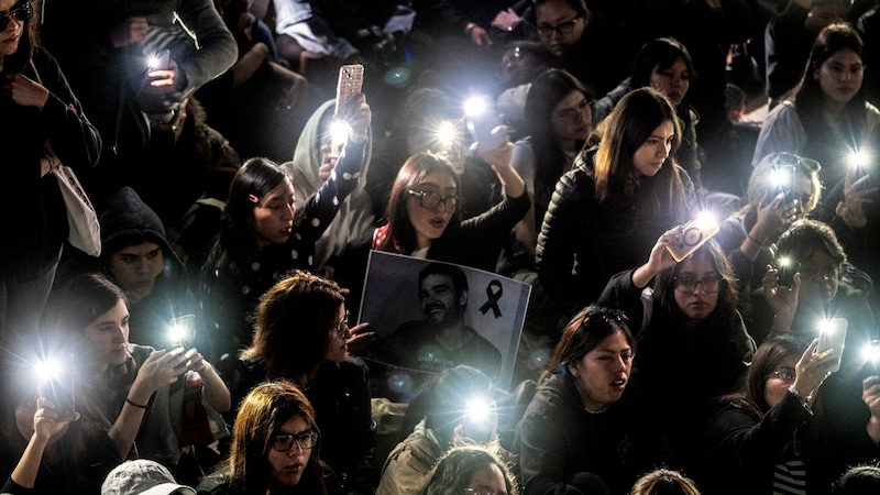 Fans pull out their smartphones at the vigil. (Bild: APA/AFP/Yuri CORTEZ)