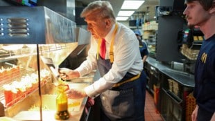 Donald Trump füllte goldbraune Pommes ab, sagte: „Es braucht tatsächlich große Expertise, um es richtig und schnell zu machen.“ (Bild: AP)