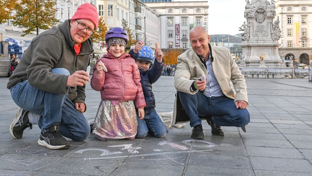 Artist and architect Clemens Bauder (left) and VP City Vice-President Martin Hajart are hoping for lots of little Linzers to join them in making the main square bright and colorful with the help of street chalks on October 27. (Bild: zVg)