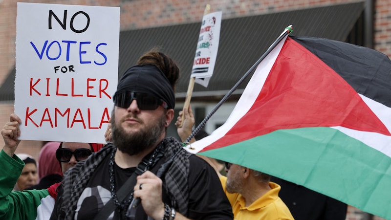 Demonstrators in Michigan hold up a sign. It reads: "No votes for murderer Kamala." (Bild: AFP/JEFF KOWALSKY)