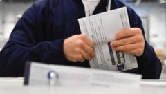 Ein Wahlhelfer mit einem Stimmzettel der US-Präsidentschaftswahl  (Bild: APA/2024 Getty Images)