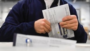 Ein Wahlhelfer mit einem Stimmzettel der US-Präsidentschaftswahl  (Bild: APA/2024 Getty Images)