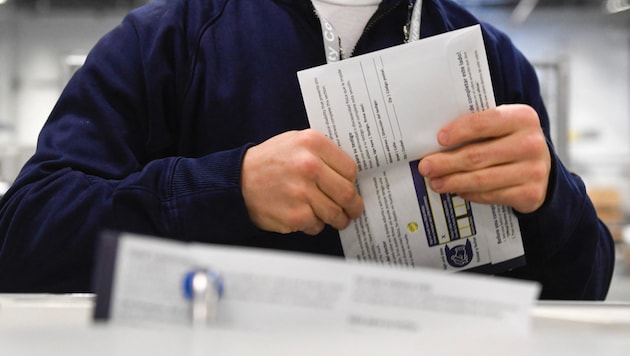 Ein Wahlhelfer mit einem Stimmzettel der US-Präsidentschaftswahl  (Bild: APA/2024 Getty Images)