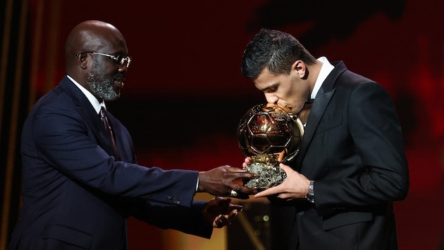 George Weah presents the award to Rodri. (Bild: APA/AFP)