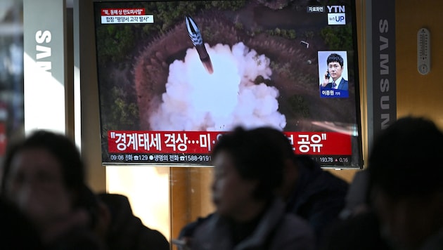 Passanten beobachten mit Sorge Aufnahmen des Raketenstarts auf einen Bildschirm in Seoul. (Bild: APA/AFP/JUNG YEON-JE)