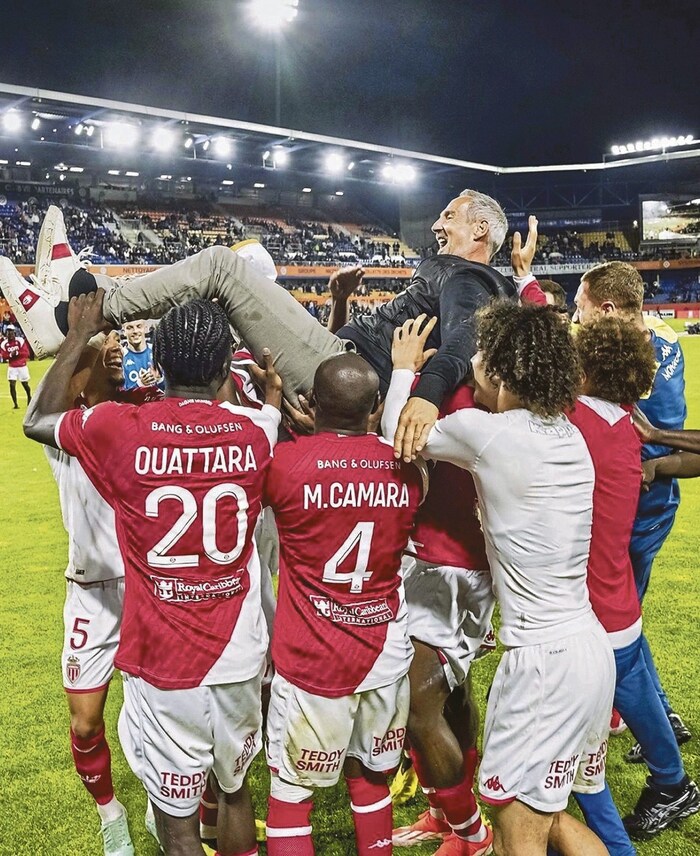 The players celebrate their successful coach.