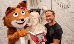 Lesefuchs Theo und Leseonkel Christian mit einem spannenden Buch im kärnten.museum