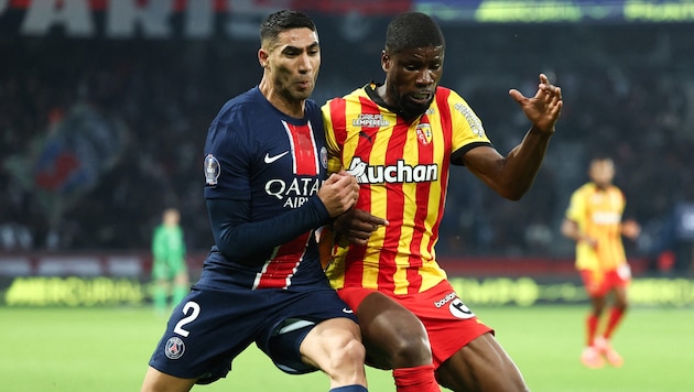 PSG star Achraf Hakimi in a duel with Austrian Lens defender Kevin Danso (Bild: AFP)