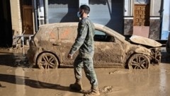 Ein Soldat neben einem zerstörten Auto in Massanassa (Bild: AFP/Jose Jordan)