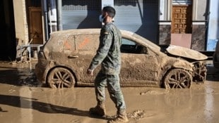 Ein Soldat neben einem zerstörten Auto in Massanassa (Bild: AFP/Jose Jordan)