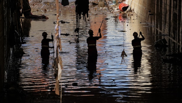 Firefighters fight against the masses of water. (Bild: AFP/Manaure Quintero)