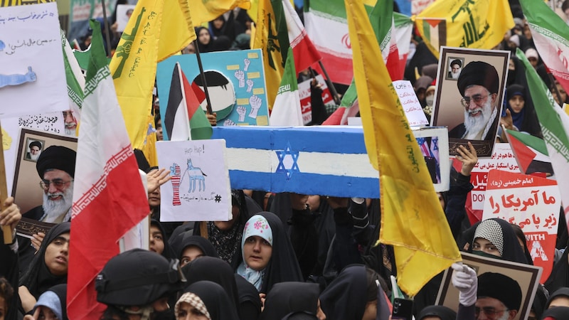 Iranerinnen tragen die israelische Flagge als Zeichen des Protests symbolisch zu Grabe. (Bild: AFP/Atta Kenare)