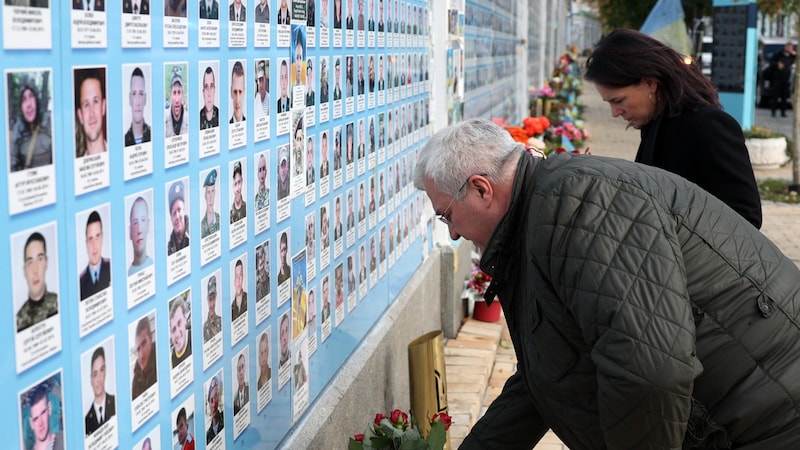 Die beiden legten Blumen bei einer Gedenkstätte nieder. (Bild: AFP/Anatolii Stepanov)