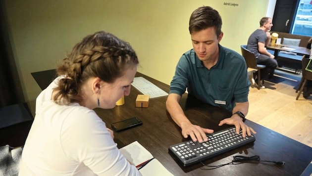 Oliver Ott explains how the keyboard template works. It prevents people from accidentally pressing several keys at the same time. (Bild: Johanna Birbaumer)