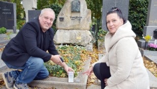 Markus Gilly und Irene Kaineder haben die neuen QR-Codes an den Ehrengräbern des Friedhofs in Mödling schon getestet. (Bild: Bernhard Garaus)