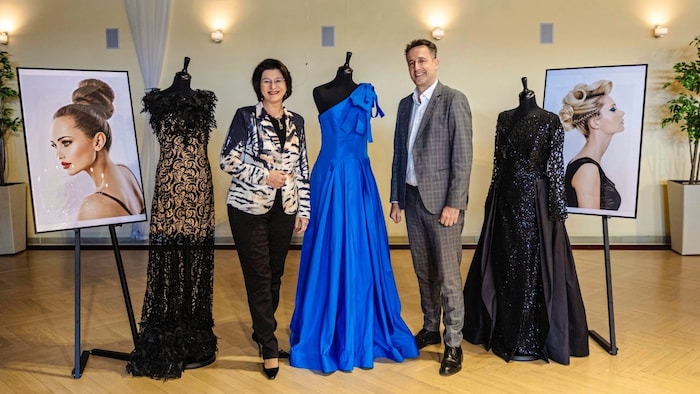 Maria Neumann and Markus Grießler, both from the Vienna Chamber of Commerce, with the dress and ...