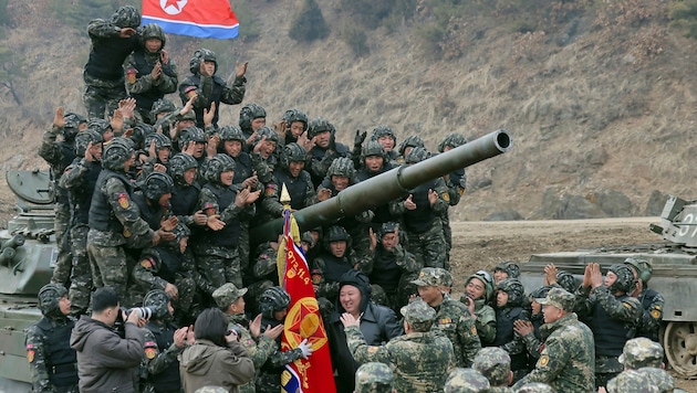 Kim Jong Un surrounded by North Korean soldiers (r. next to flag with black hood) (Bild: AP/Korean Central News Agency/Korea News Service via AP, File)