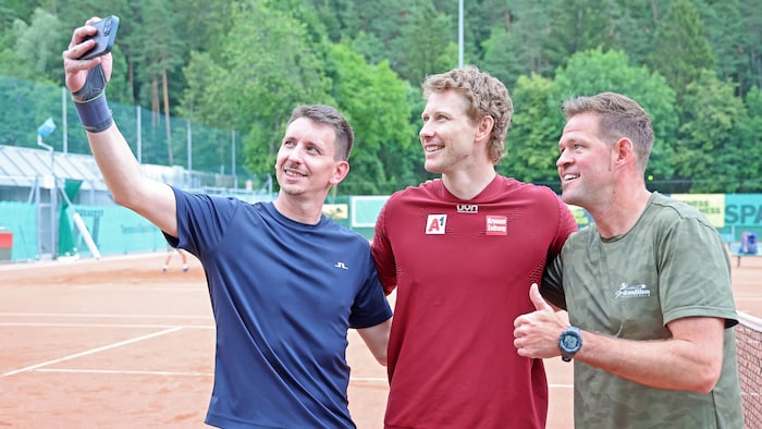 ... and takes time for fan photos on his home tennis court.