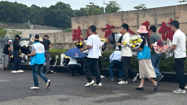 Grieving people lay flowers at the scene of the crime. (Bild: APA Pool/AP)