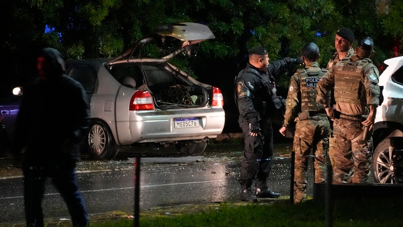 Ein Auto wird nach den Explosionen vor dem Obersten Gerichtshof untersucht. (Bild: APA/ Associated Press)