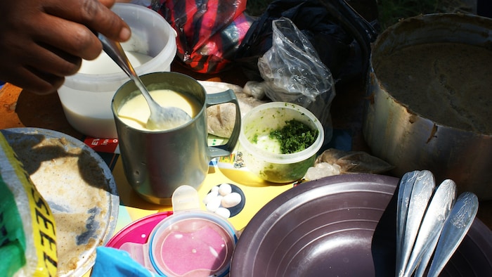 A mother in Zambia prepares oatmeal porridge for her baby.